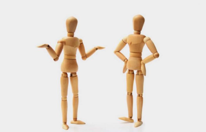 Two wooden marrionettes in different gestures and poses.